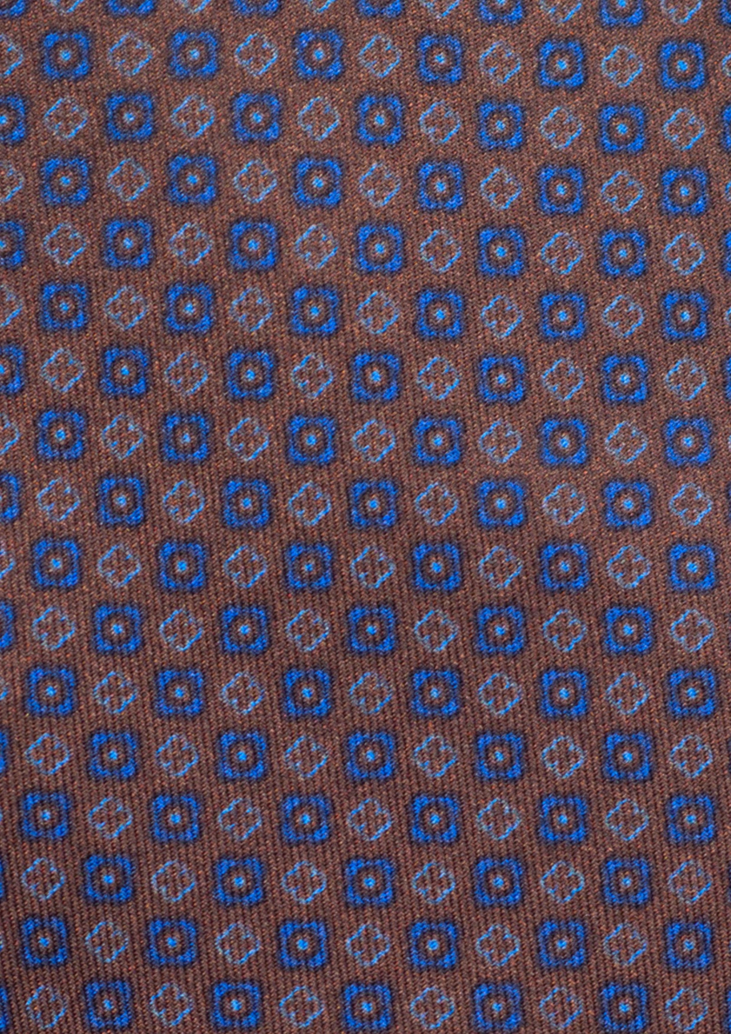 Cravate en twill 100% soie, ornée d'un motif de fleurs bleues sur fond marron