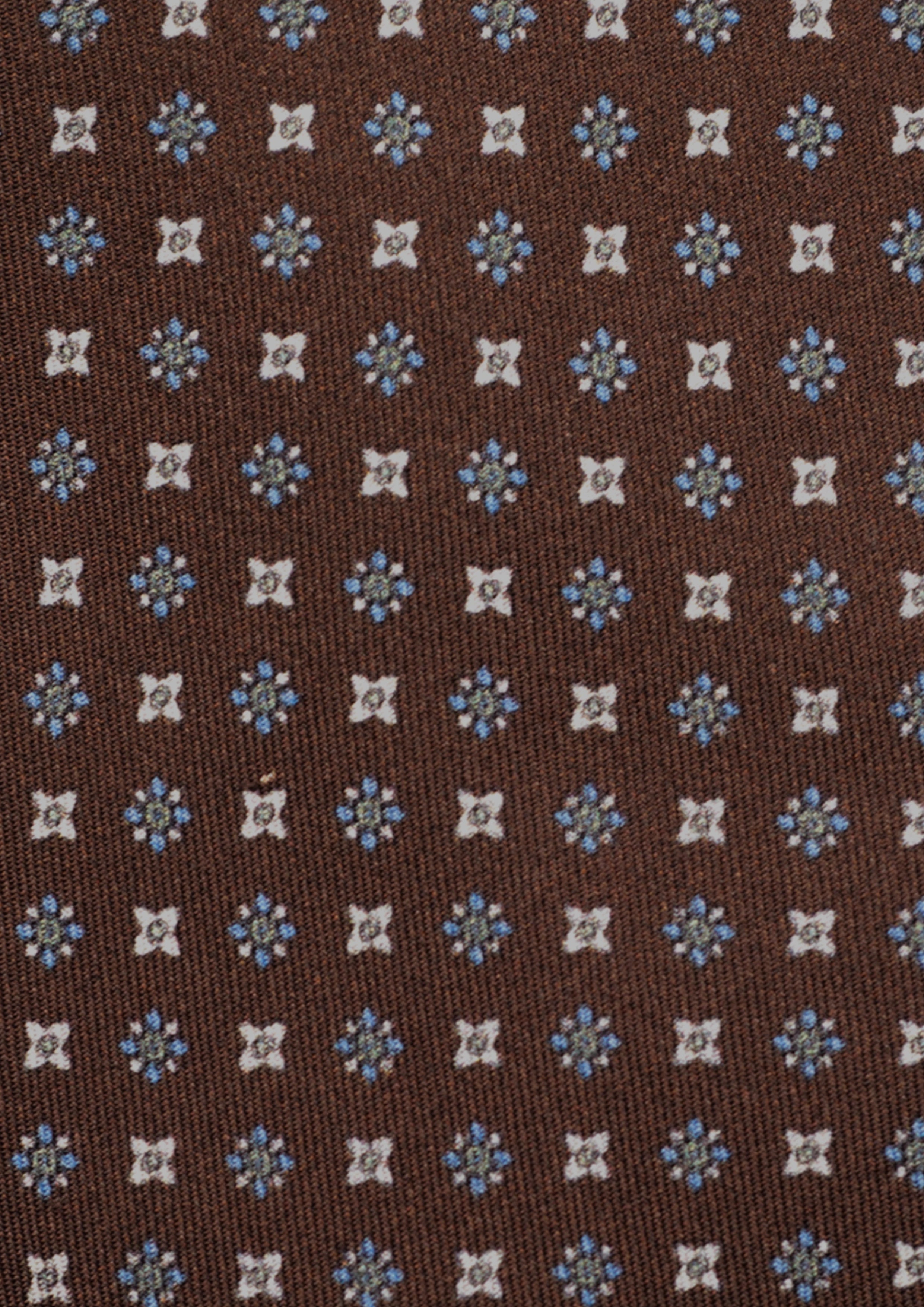 Cravate en twill 100% soie, ornée d'un motif de fleurs bleues et blanches sur fond marron
