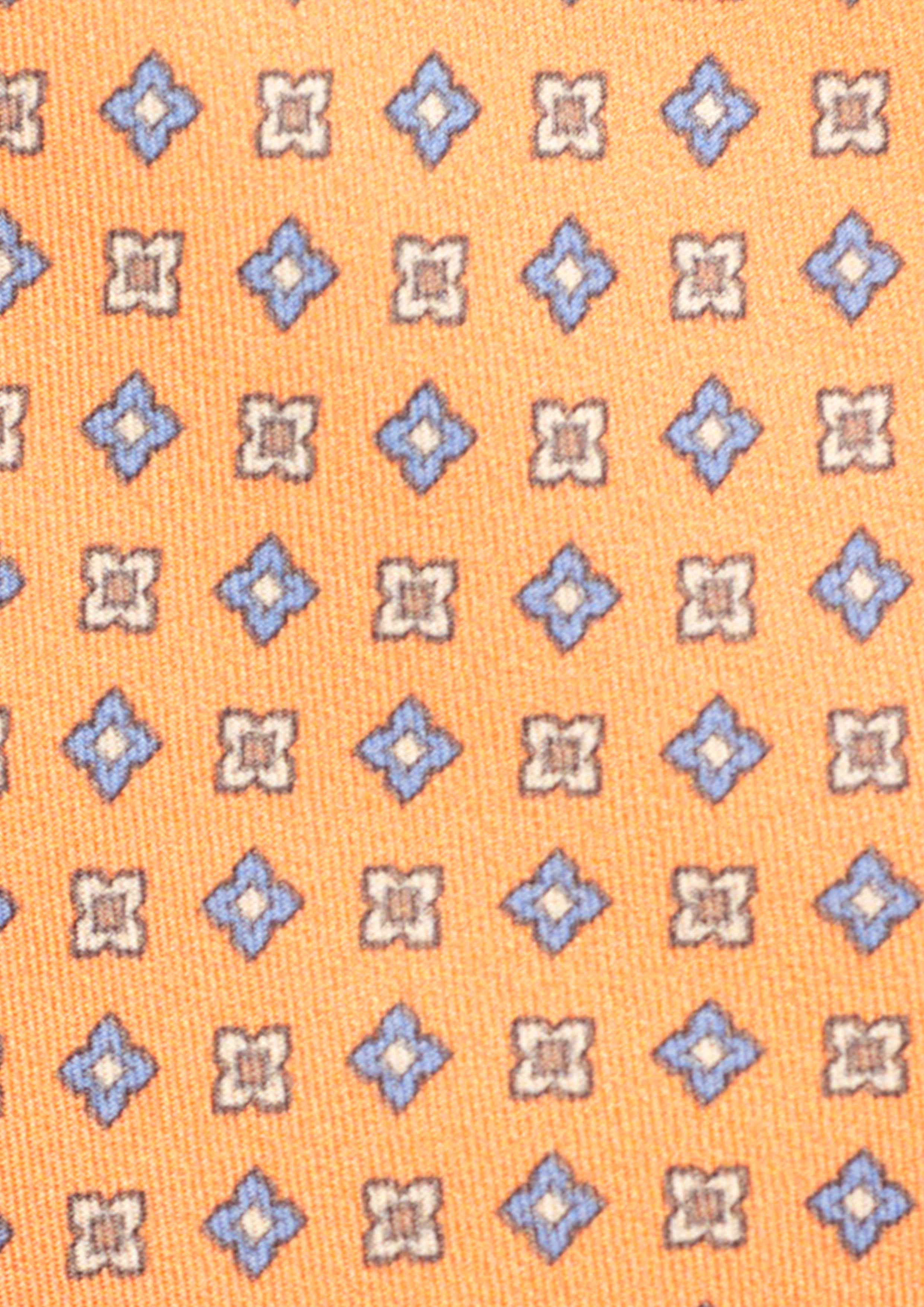 Cravate en twill 100% soie, ornée d'un motif de fleurs bleues et blanches sur fond orange