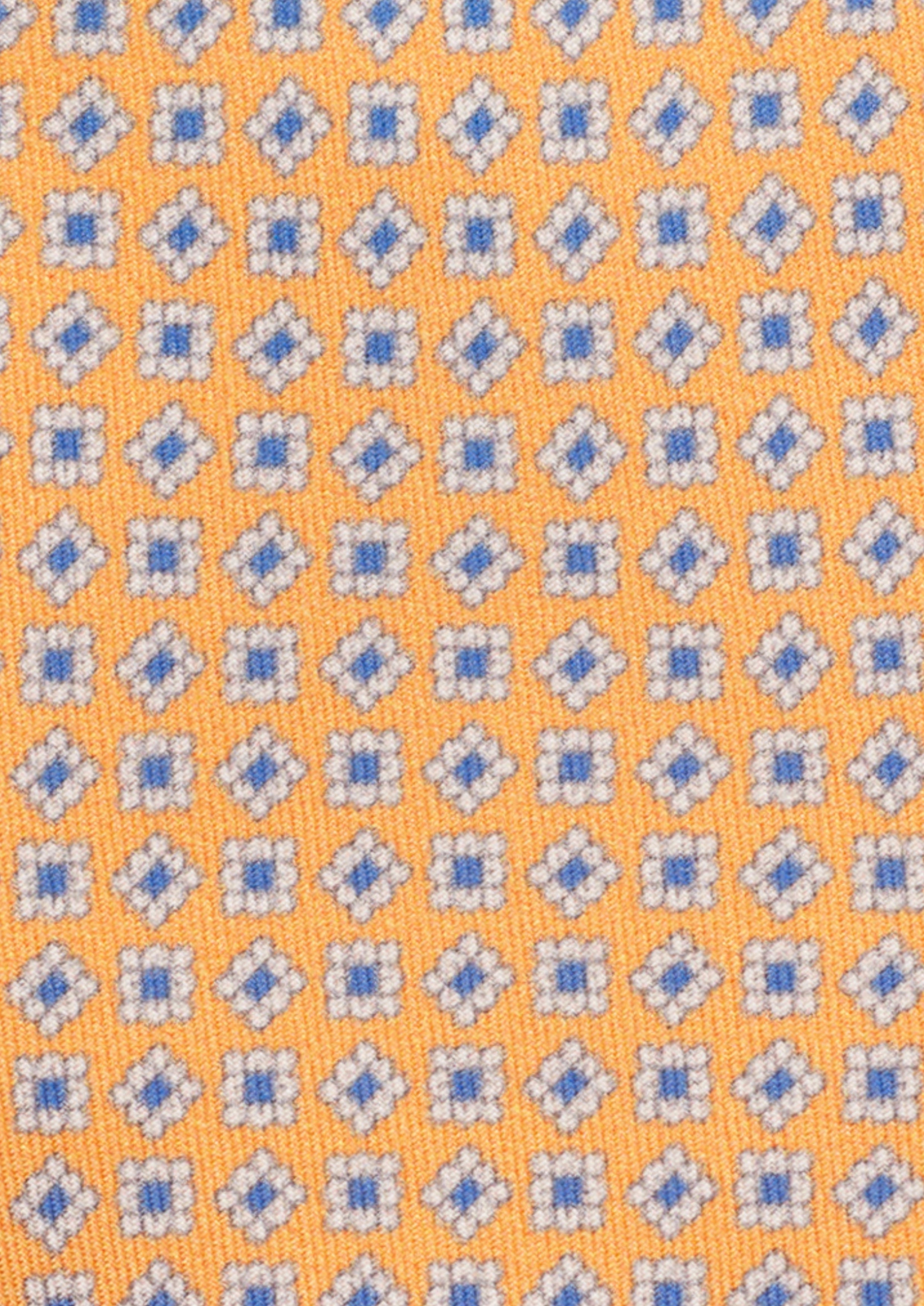 Cravate en twill 100% soie, ornée d'un motif de fleurs bleues et blanches sur fond orange