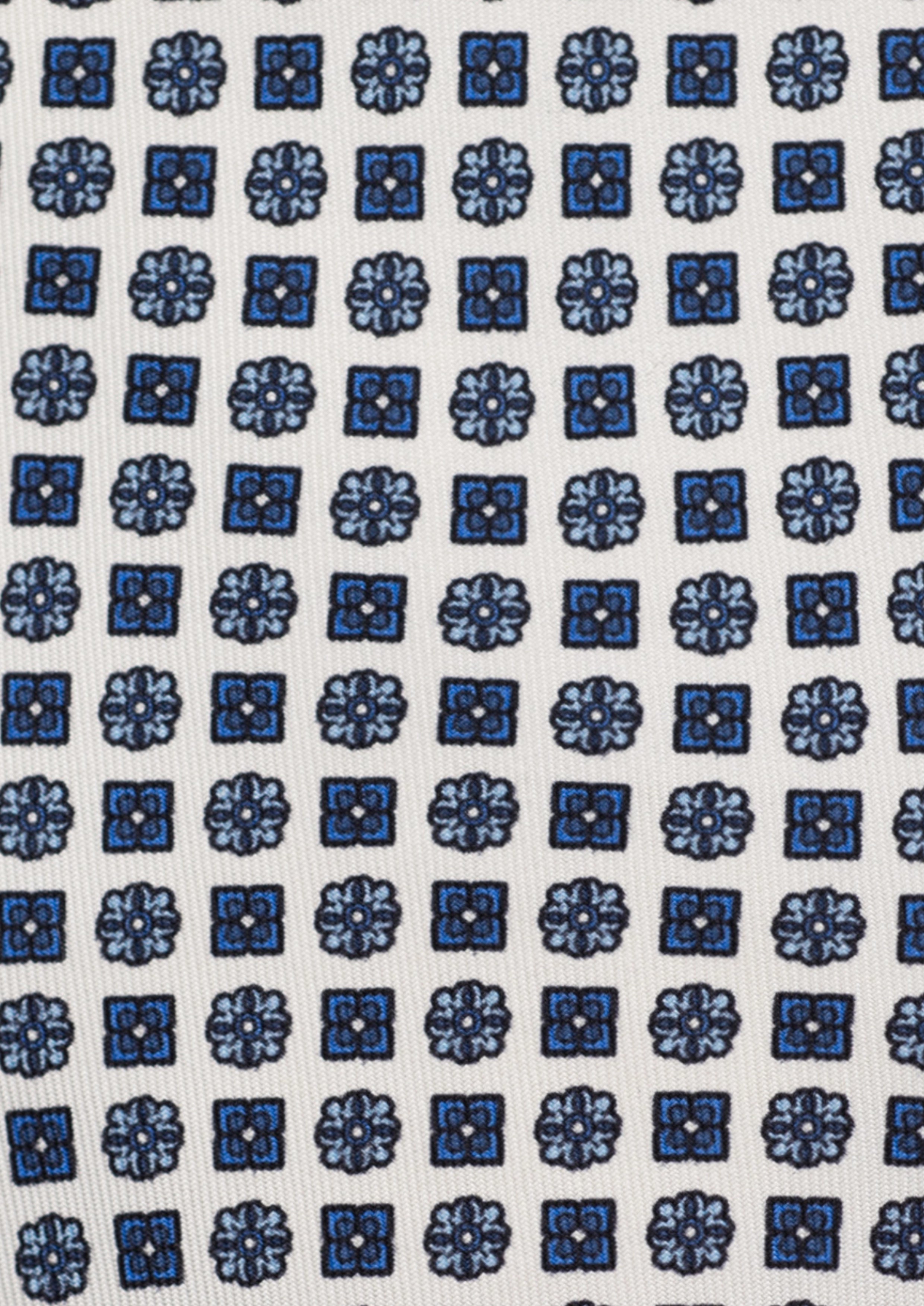 Cravate en twill 100% soie, ornée d'un motif de fleurs bleues sur fond blanc