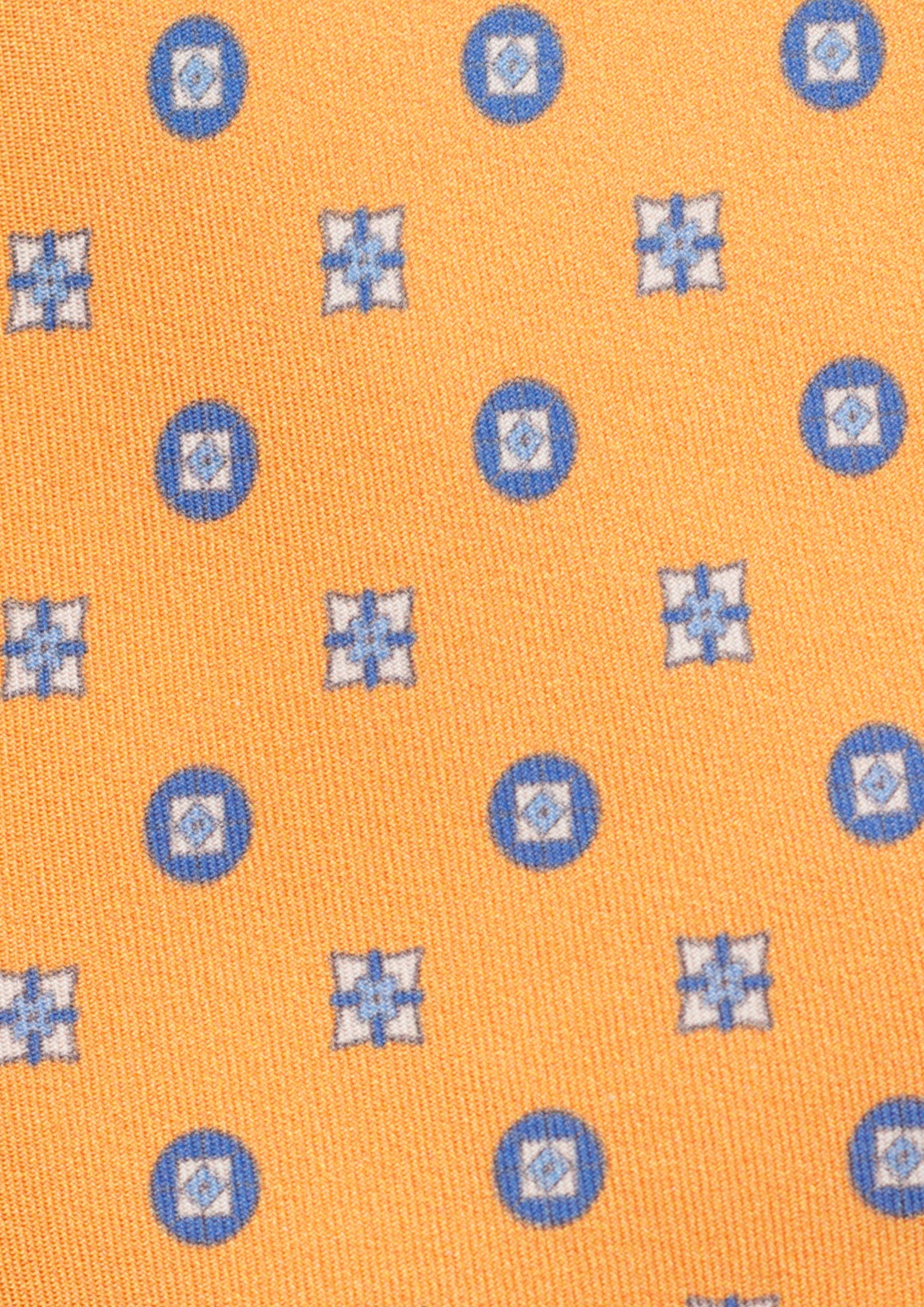 Cravate en twill 100% soie, ornée d'un motif de fleurs bleues sur fond orange