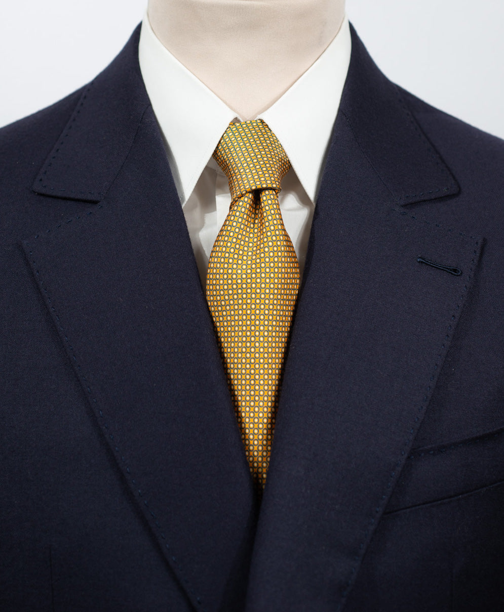 Cravate en twill 100% soie, ornée d'un motif géométrique bleu et blanc sur fond jaune