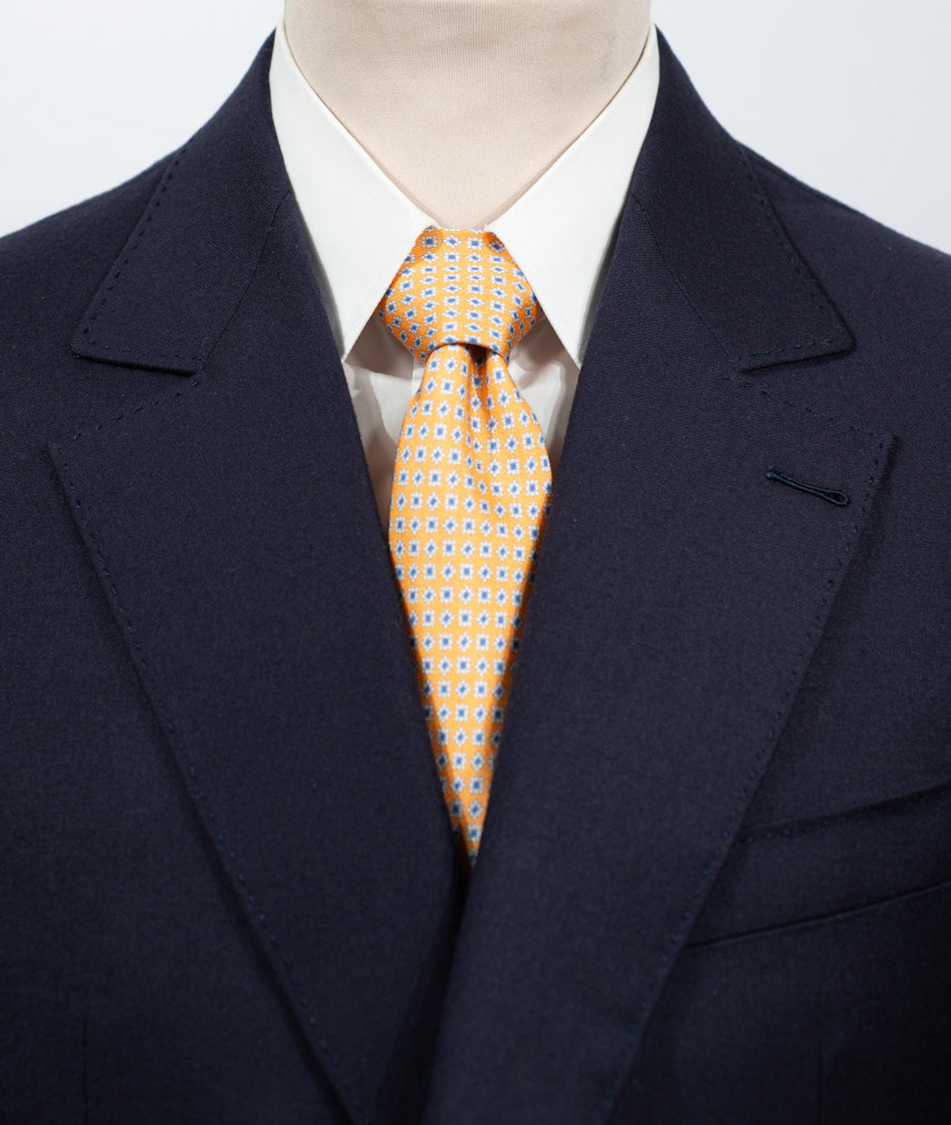 Cravate en twill 100% soie, ornée d'un motif de fleurs bleues et blanches sur fond orange