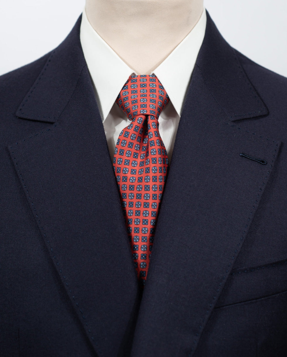 Cravate en twill 100% soie, ornée d'un motif de fleurs bleues sur fond rouge