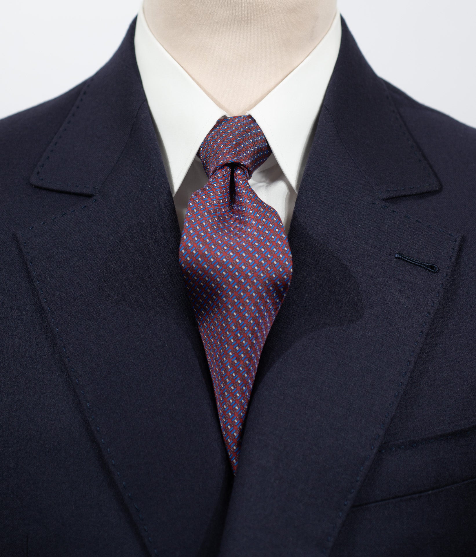 Cravate en twill 100% soie, ornée d'un motif géométrique bleu et blanc sur fond rouge