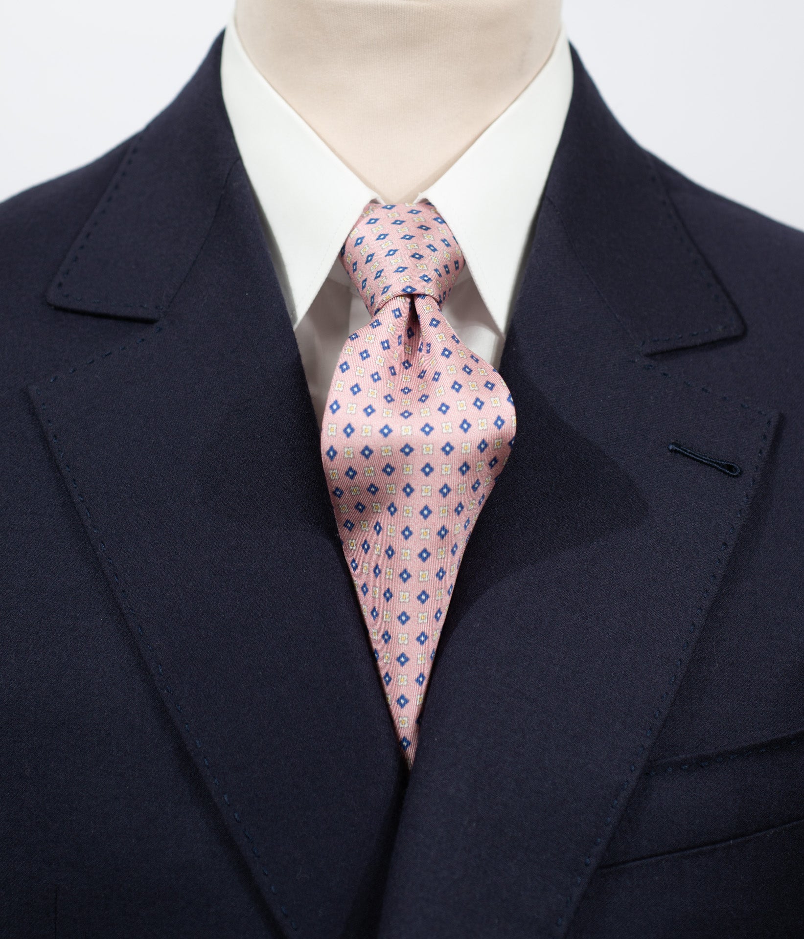 Cravate en twill 100% soie, ornée d’un motif de fleurs bleues et blanches sur fond rose