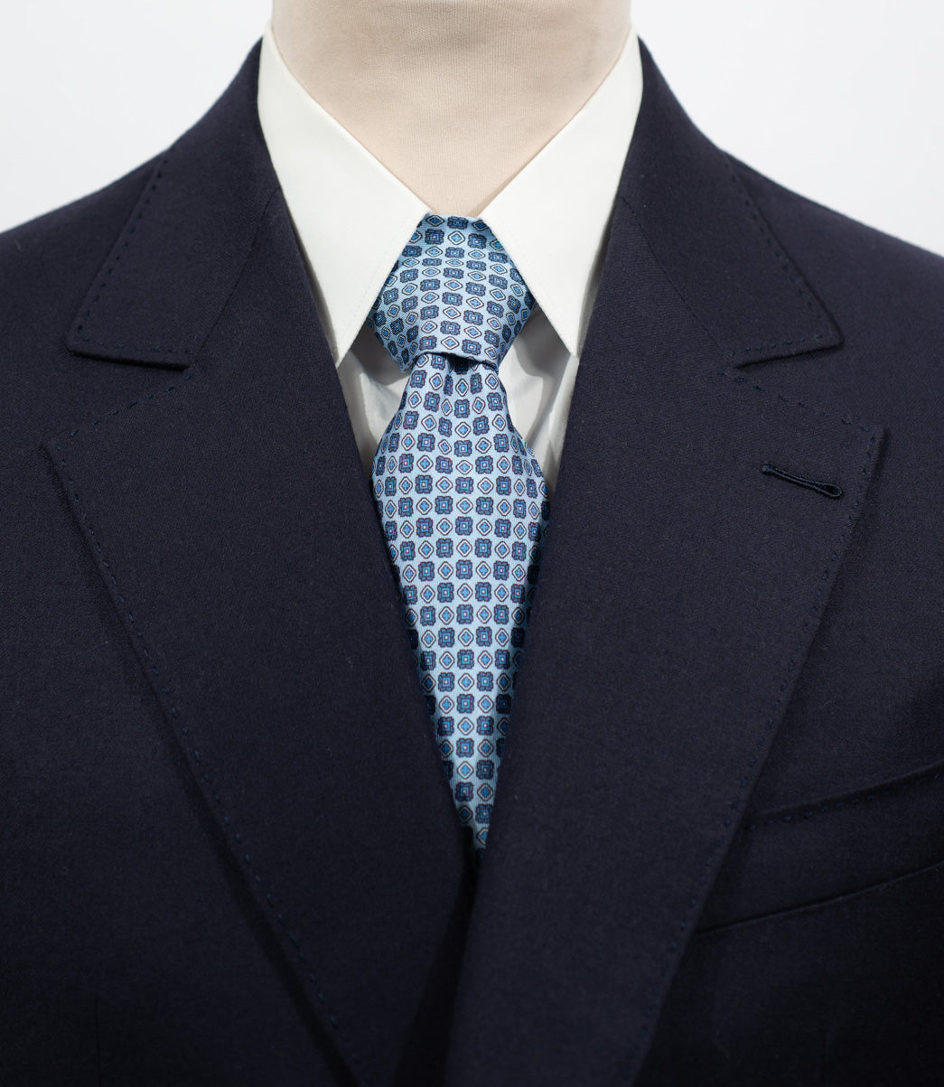 Cravate en twill 100 % soie, ornée d'un motif de fleurs bleues sur fond bleu ciel