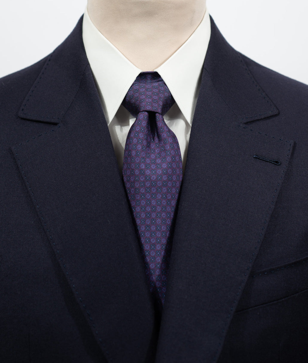 Cravate en twill 100% soie, ornée d'un motif de fleurs bleues sur fond violet