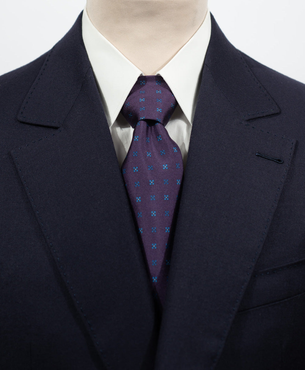Cravate en twill 100% soie, ornée d'un motif de fleurs bleues sur fond violet