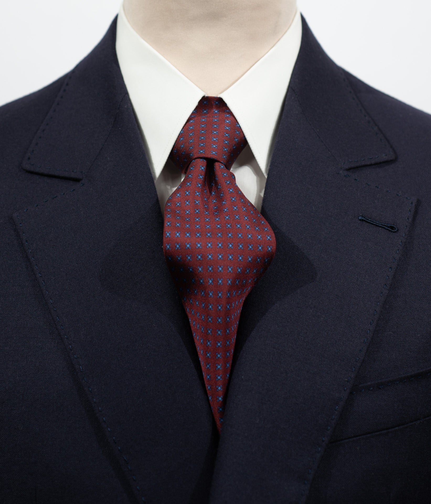 Cravate en twill 100% soie, ornée d'un motif de fleurs bleues sur fond rouge