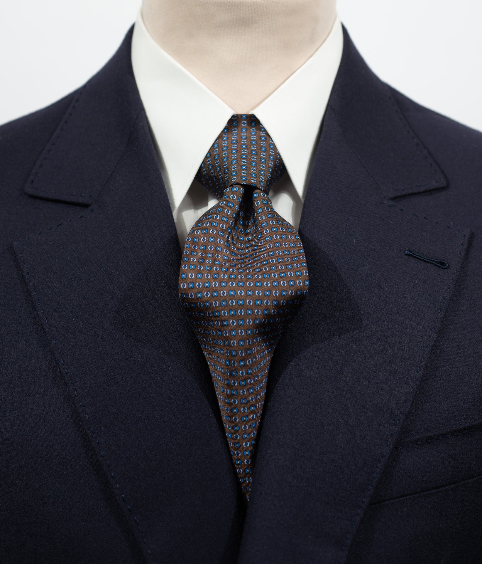 Cravate en twill 100% soie, ornée d'un motif bleu sur fond marron