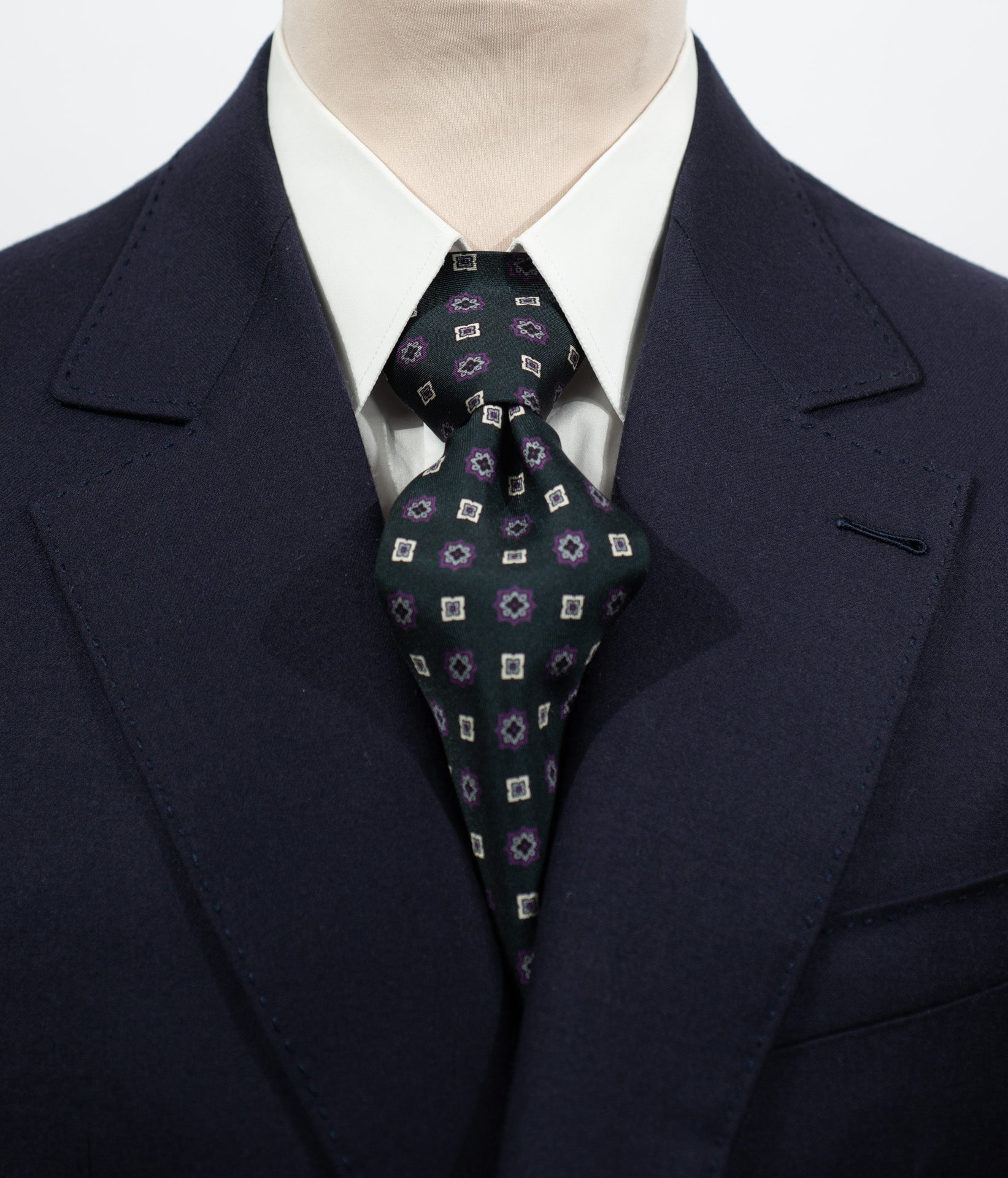 Cravate en twill 100% soie, ornée d'un motif de fleurs blanches et violettes sur fond vert foncé