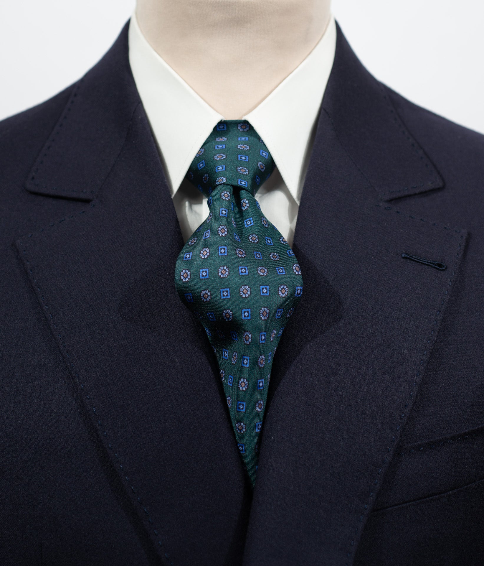 Cravate en twill 100% soie, ornée d'un motif de fleurs bleues sur fond vert