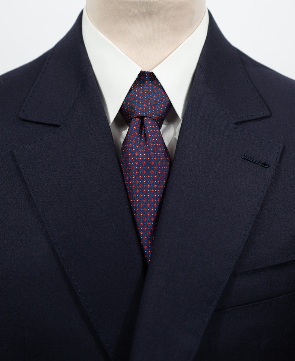 Cravate en twill 100% soie, ornée d'un motif de fleurs rouges sur fond bleu