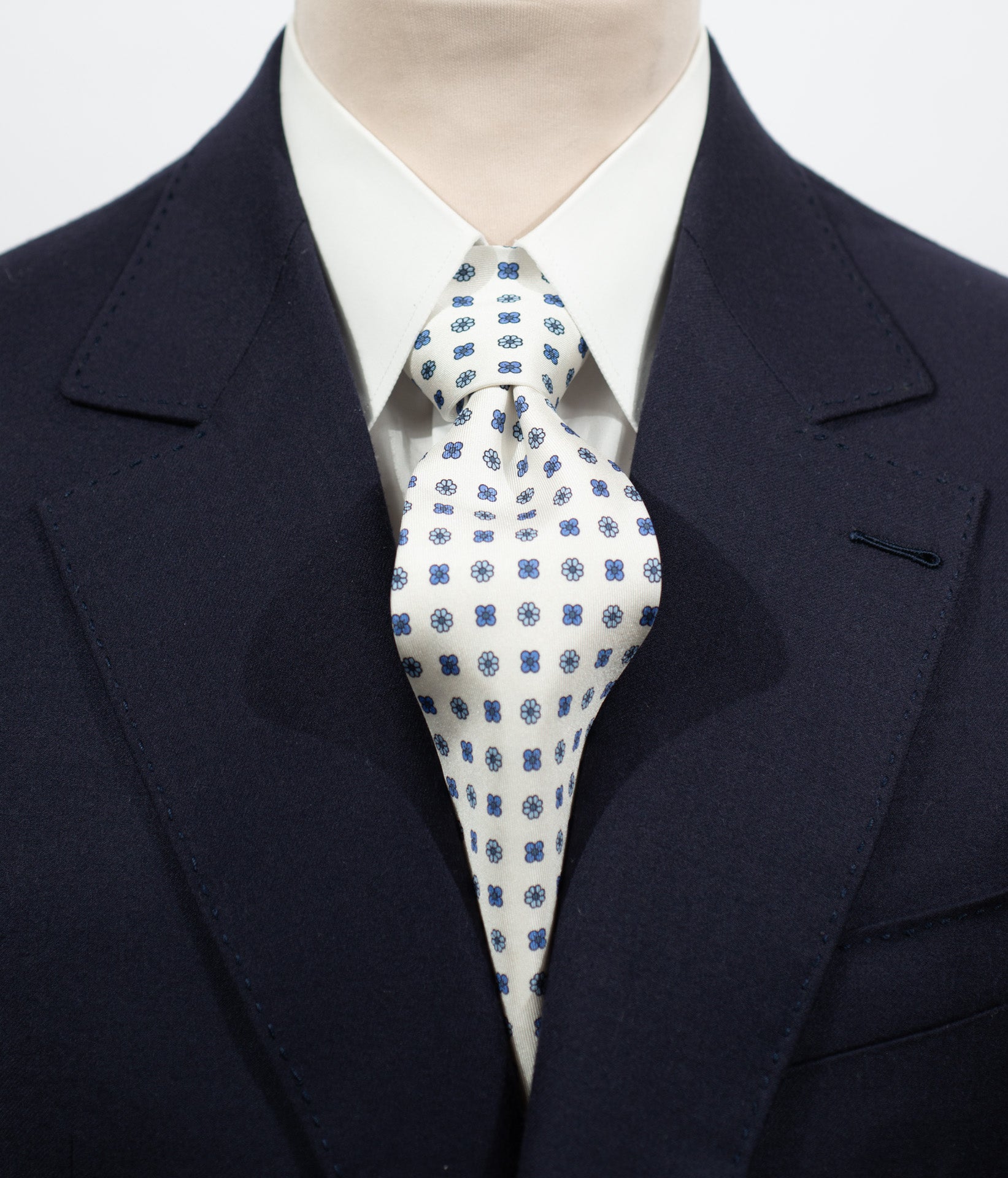 Cravate en twill 100% soie, ornée d'un motif de fleurs bleues sur fond blanc