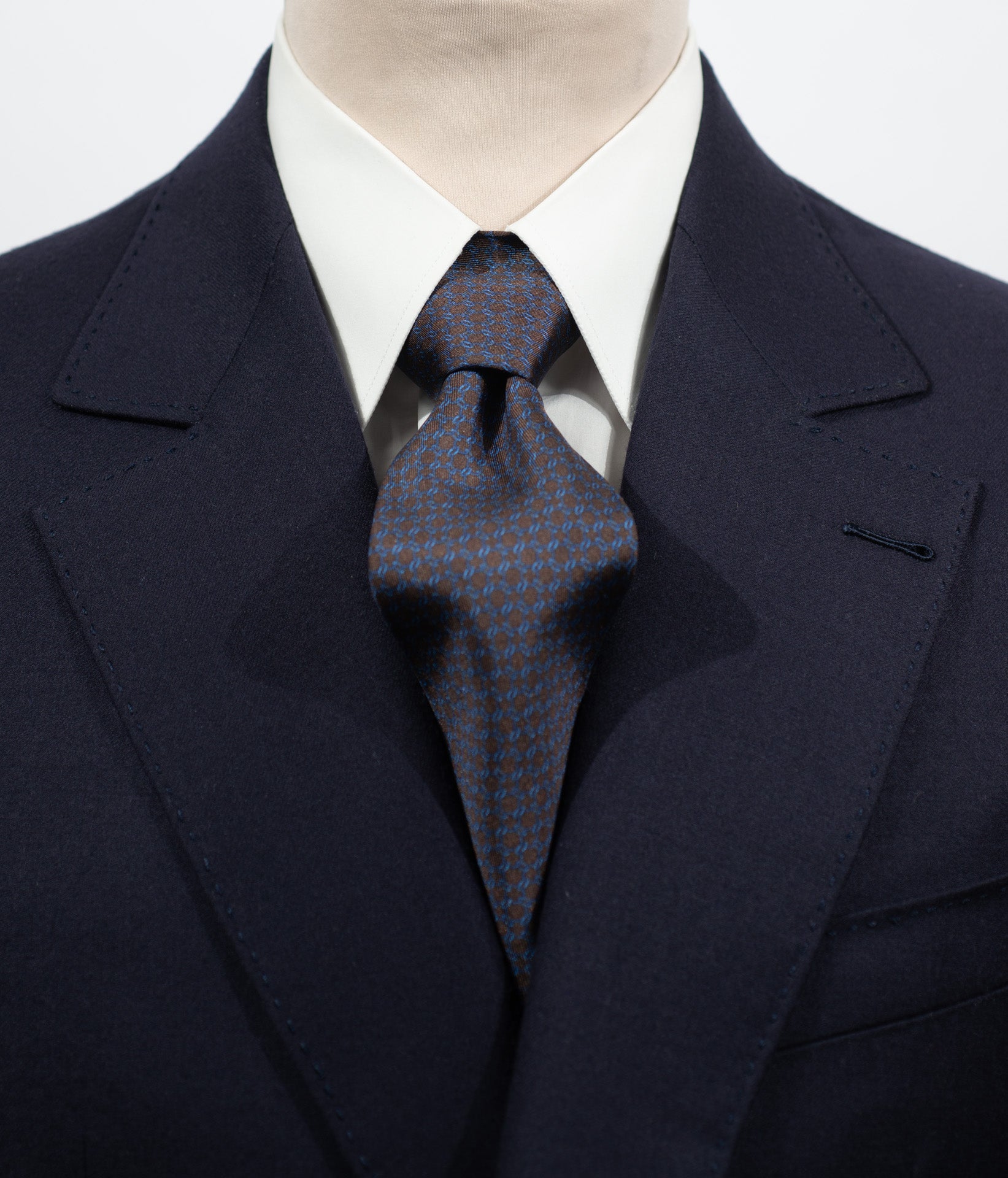 Cravate en twill 100% soie, ornée d'un motif géométrique bleu sur fond marron