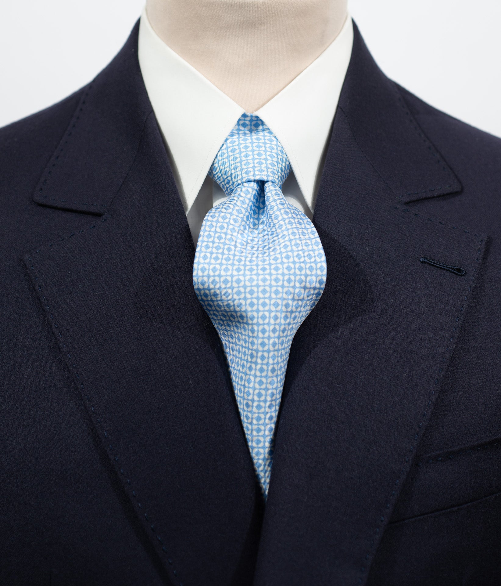 Cravate en twill 100% soie, ornée d'un motif de fleurs blanches sur fond bleu