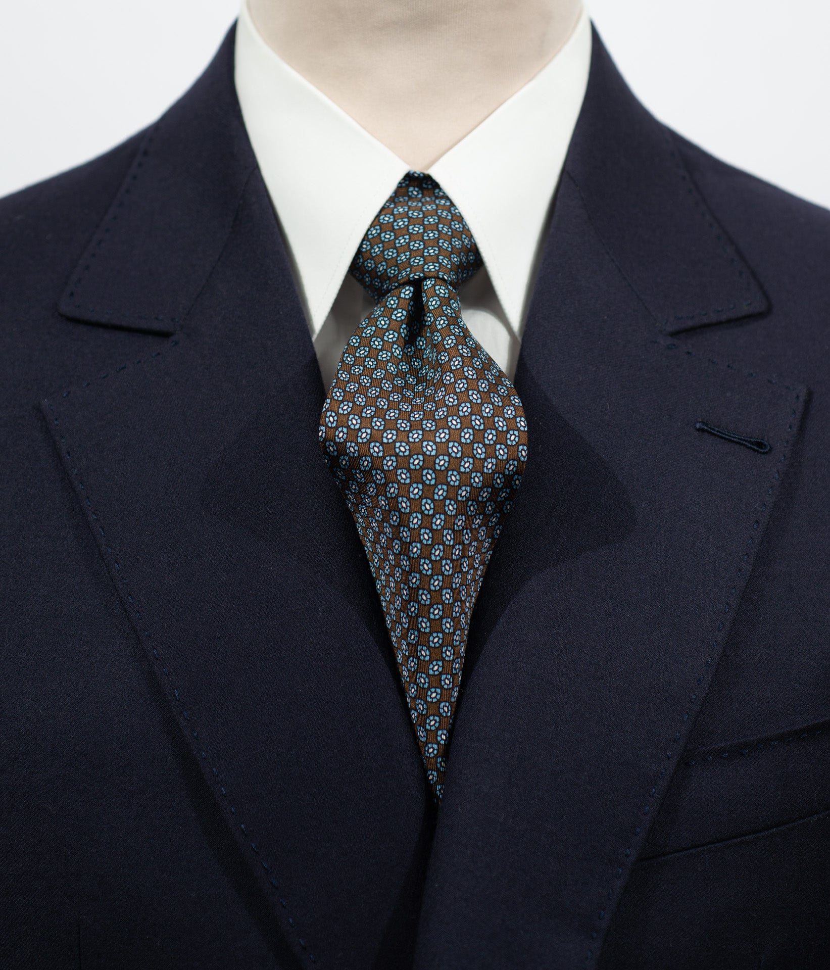 Cravate en twill 100% soie, ornée d'un motif barquette bleu et blanc sur fond marron