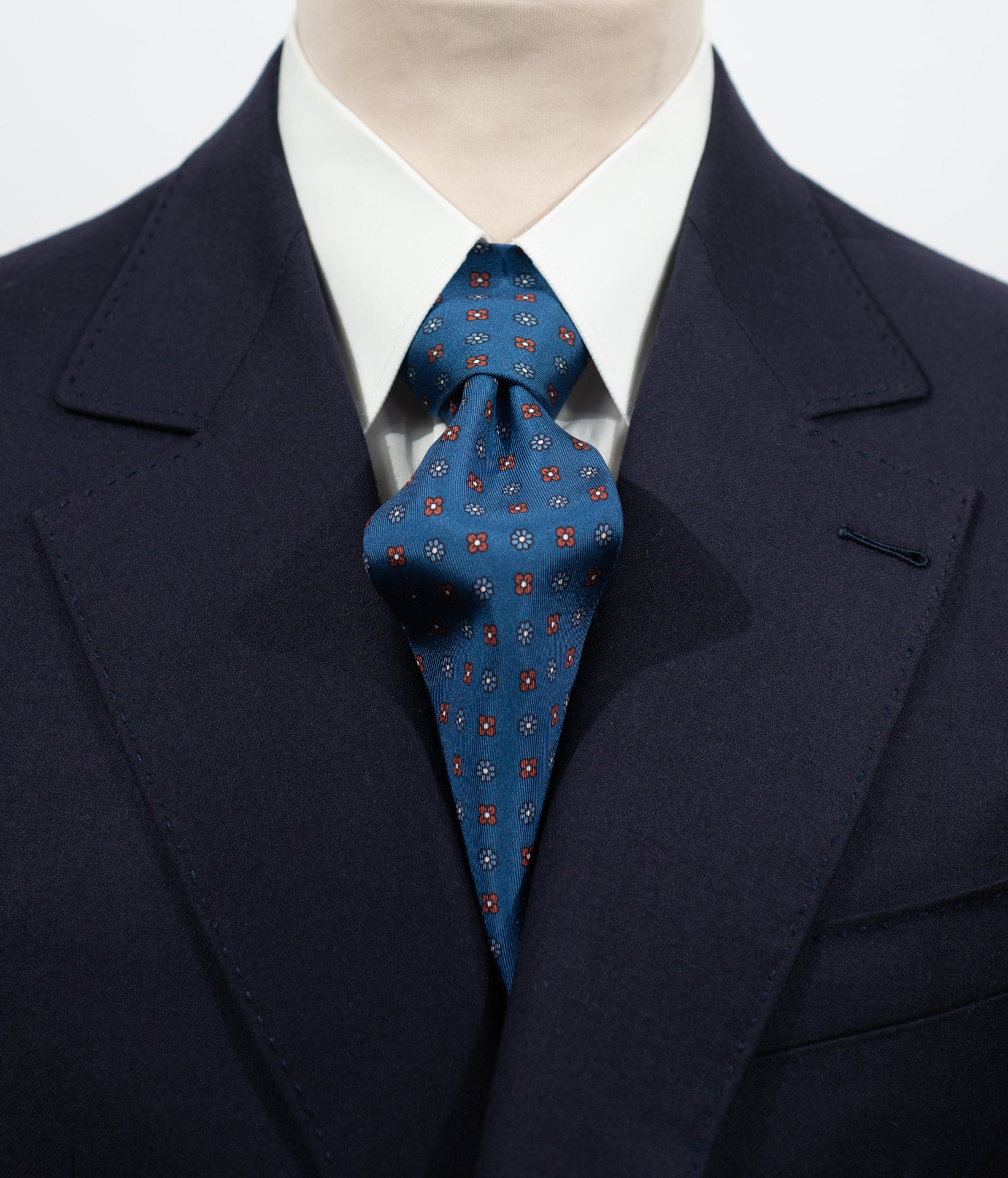 Cravate en twill 100% soie, ornée d'un motif de fleurs bleues et rouges sur fond bleu