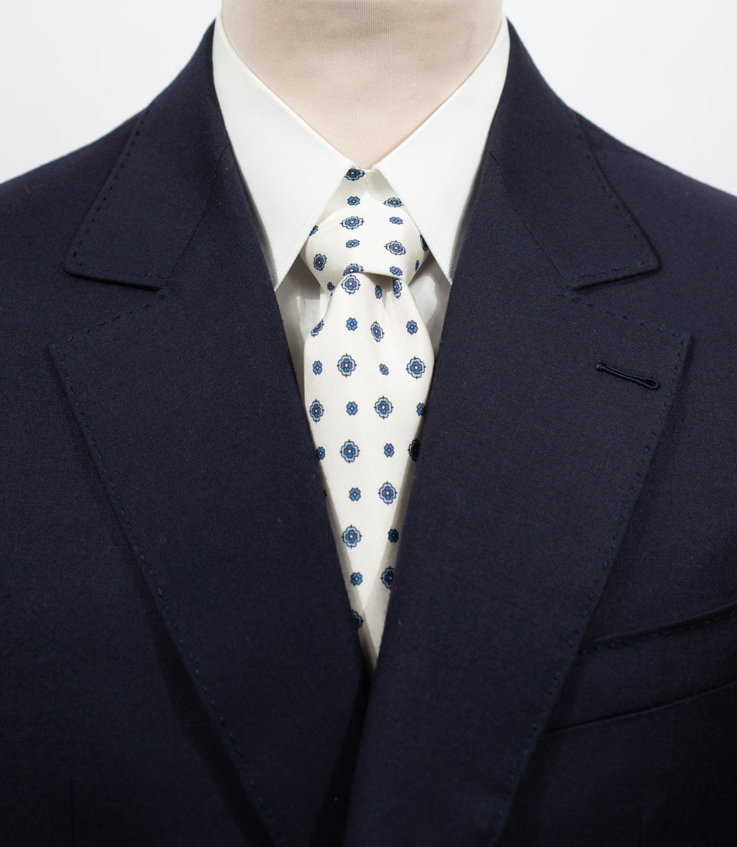 Cravate en twill 100% soie, ornée d'un motif de fleurs bleues sur fond blanc