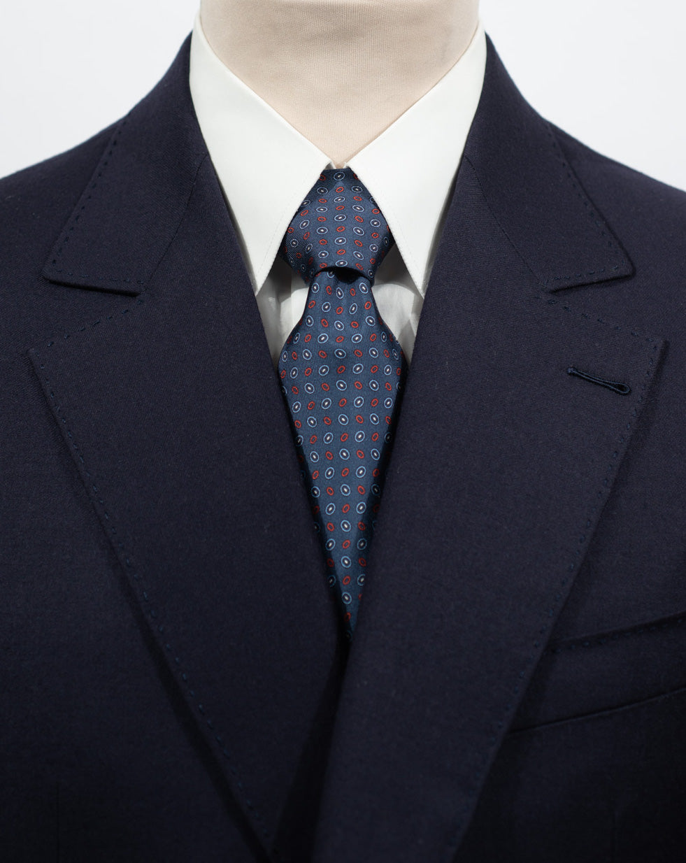 Cravate en twill 100% soie, ornée d'un motif ovale rouge et blanc sur fond bleu